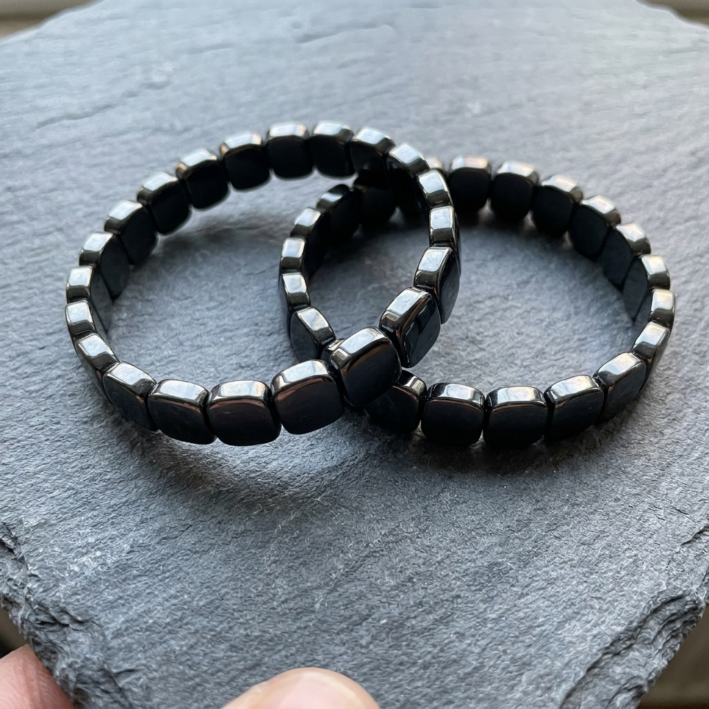 Two Hematite Bands resting on a slate surface in a customer's photo